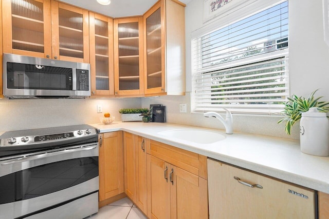 kitchen with light tile patterned floors, sink, and stainless steel appliances