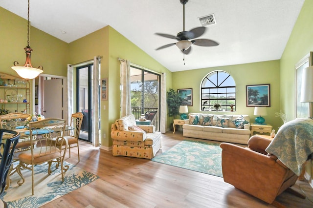 living room featuring ceiling fan, plenty of natural light, light hardwood / wood-style floors, and lofted ceiling