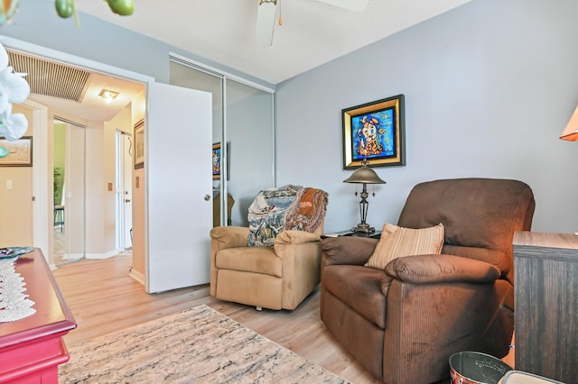 sitting room with ceiling fan and light hardwood / wood-style floors