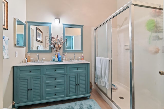 bathroom featuring hardwood / wood-style floors, vanity, and a shower with shower door