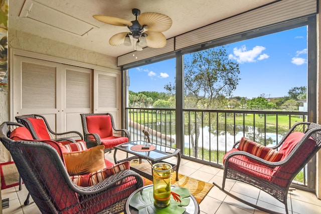 sunroom / solarium featuring ceiling fan, a water view, and plenty of natural light