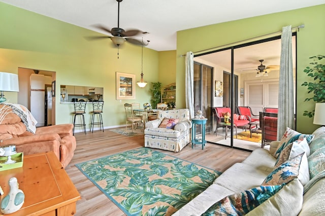 living room with ceiling fan and light hardwood / wood-style flooring