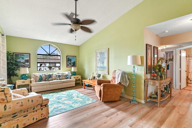 living room with a textured ceiling, light hardwood / wood-style flooring, ceiling fan, and lofted ceiling