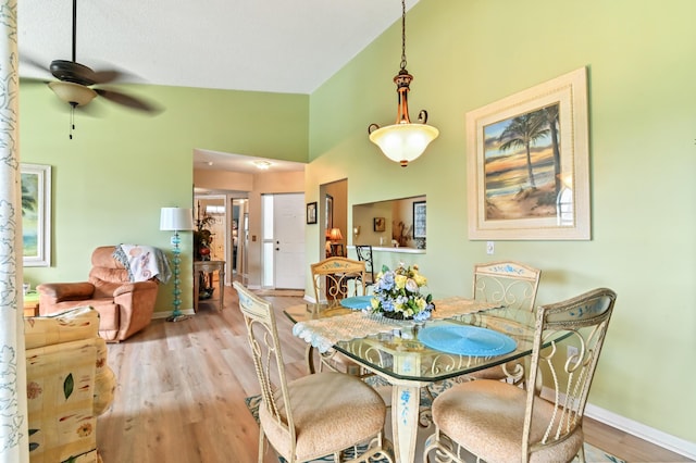 dining area featuring light hardwood / wood-style floors, high vaulted ceiling, and ceiling fan