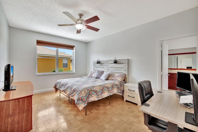 bedroom with ceiling fan, light parquet floors, and a textured ceiling