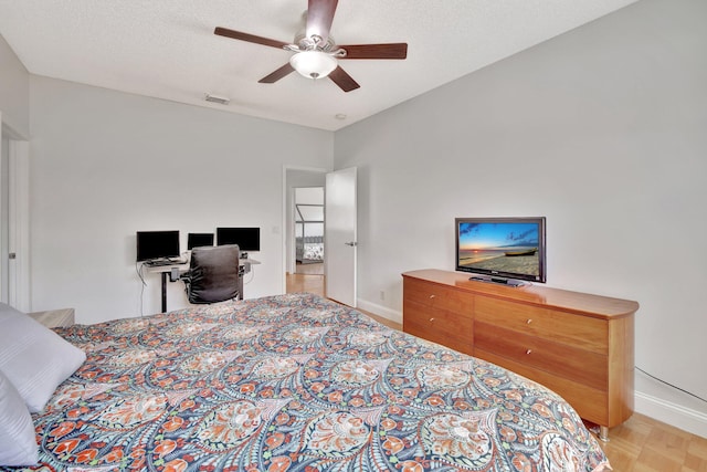 bedroom featuring a textured ceiling, ceiling fan, and parquet floors