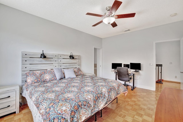 bedroom featuring light parquet flooring, ceiling fan, and a textured ceiling