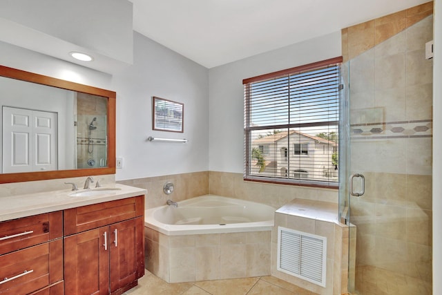 bathroom featuring tile flooring, oversized vanity, and separate shower and tub