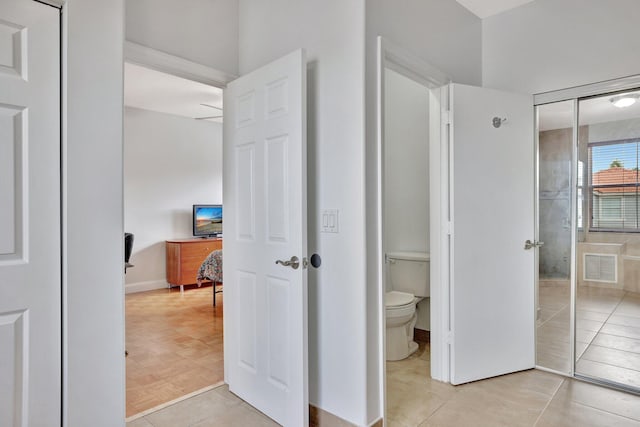 interior space featuring light tile floors and ensuite bathroom