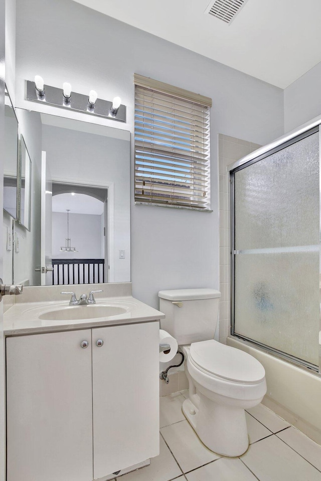 full bathroom with tile flooring, vanity, toilet, and shower / bath combination with glass door