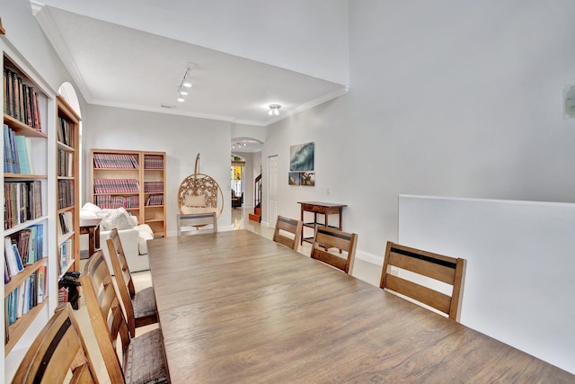 interior space with hardwood / wood-style floors, crown molding, and track lighting