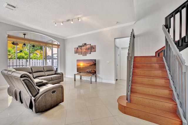 living room with crown molding, a textured ceiling, light tile floors, and track lighting