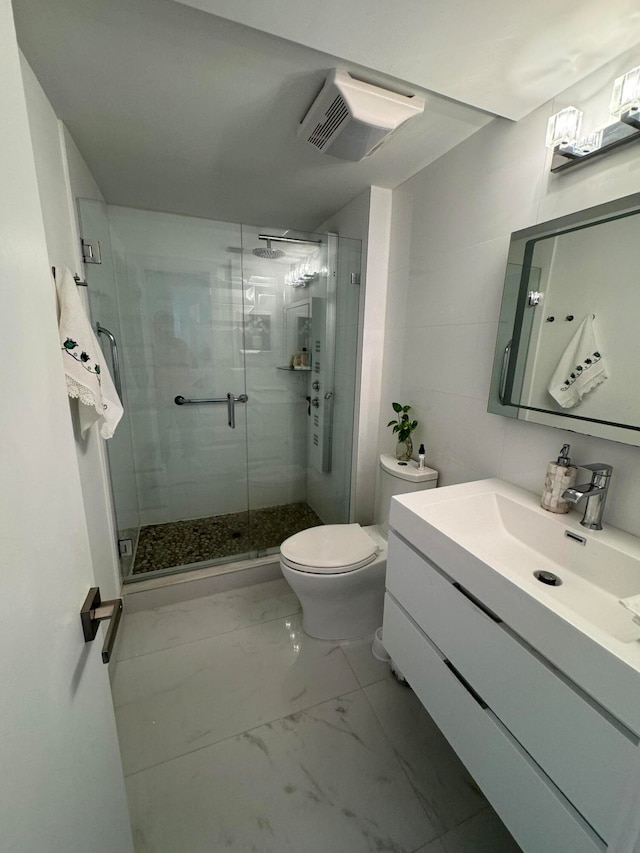 bathroom with walk in shower, vanity, and toilet