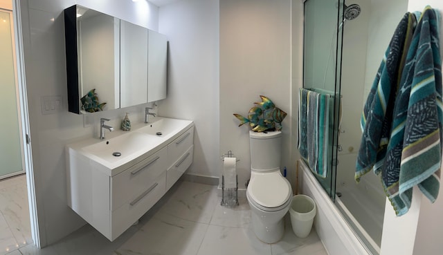 full bathroom featuring combined bath / shower with glass door, vanity, and toilet