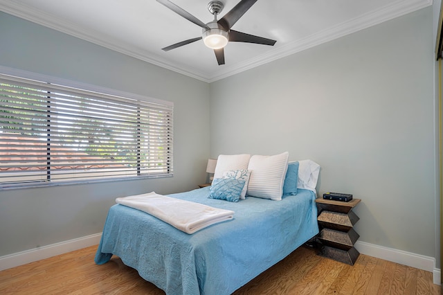 bedroom featuring ceiling fan, ornamental molding, and hardwood / wood-style floors