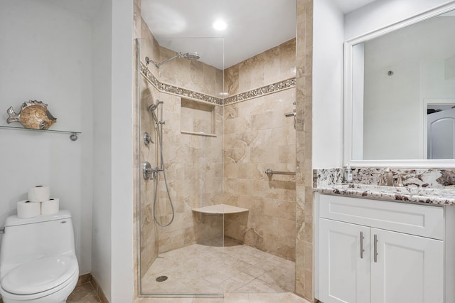 bathroom featuring tiled shower, vanity, and toilet