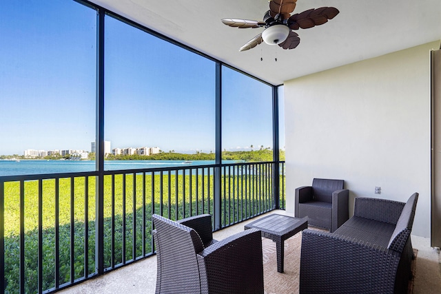 sunroom with ceiling fan, a water view, and plenty of natural light