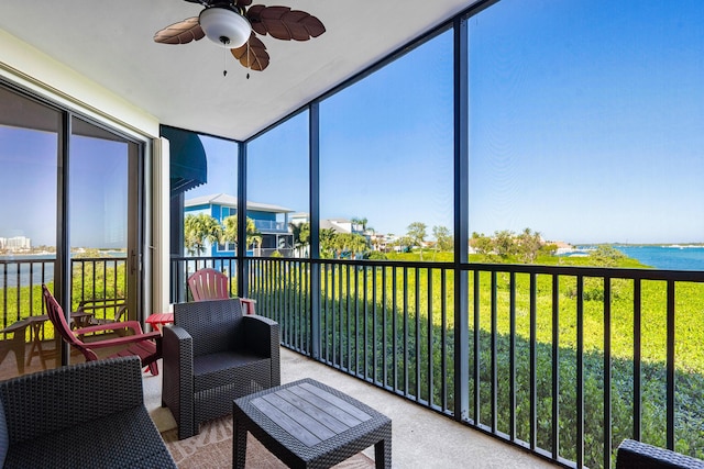 sunroom featuring a water view and ceiling fan