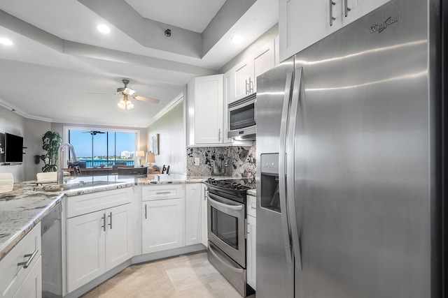 kitchen featuring stainless steel appliances, light stone countertops, sink, ornamental molding, and white cabinets