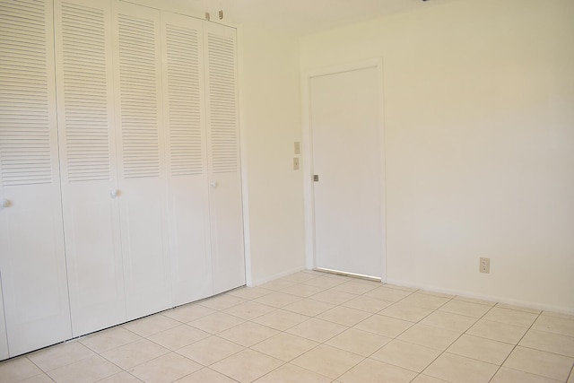 unfurnished bedroom featuring a closet and light tile patterned floors