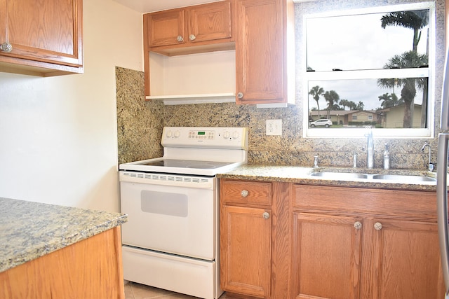 kitchen with light tile patterned floors, sink, white range with electric cooktop, and backsplash