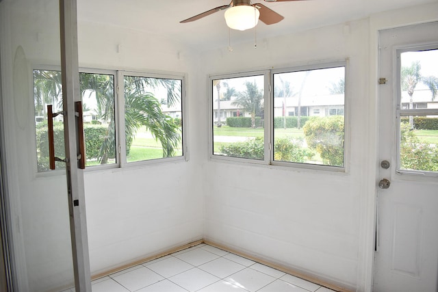 unfurnished sunroom featuring a wealth of natural light and ceiling fan