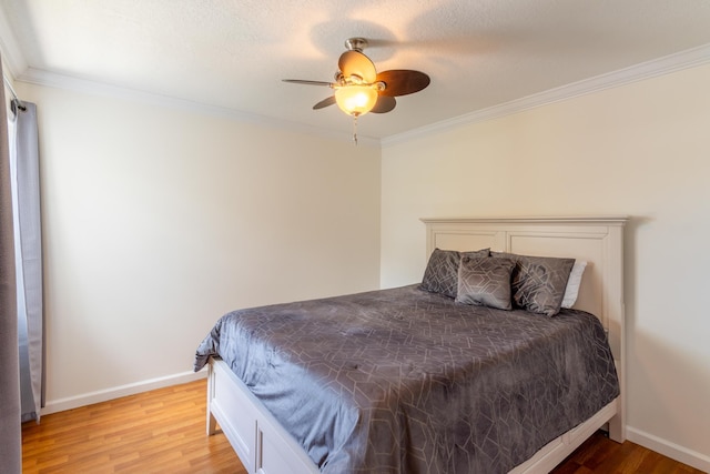 bedroom featuring a textured ceiling, light wood-type flooring, ceiling fan, and ornamental molding