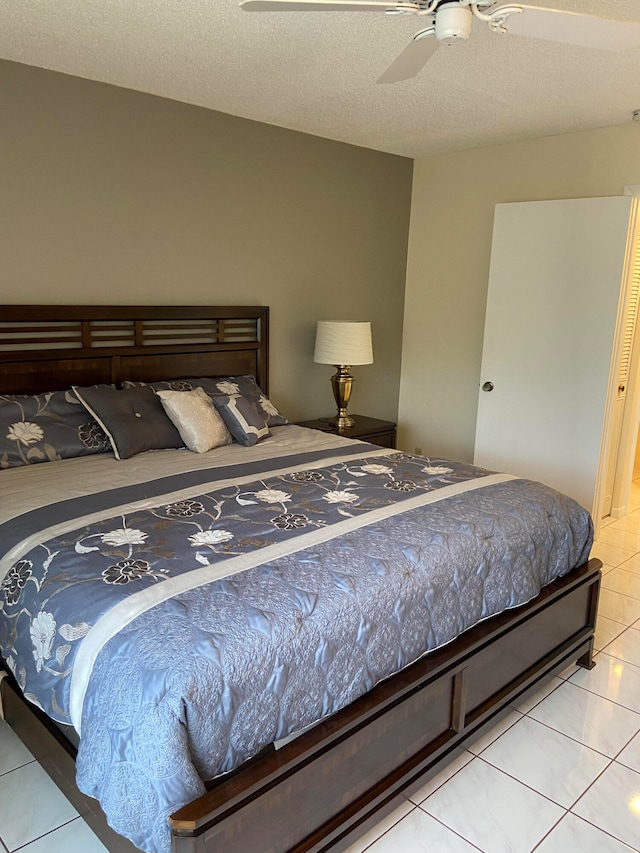 tiled bedroom with a textured ceiling and ceiling fan