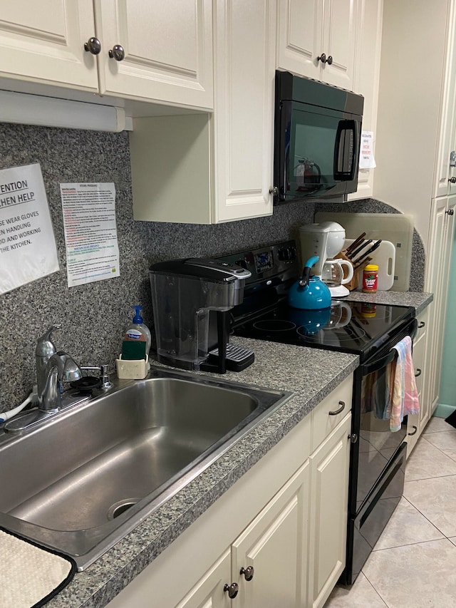 kitchen featuring black appliances, decorative backsplash, light tile patterned flooring, and sink