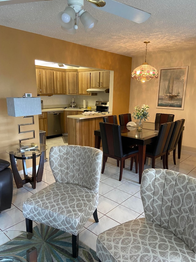 kitchen featuring appliances with stainless steel finishes, hanging light fixtures, light tile patterned flooring, kitchen peninsula, and ceiling fan