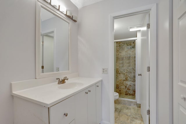 bathroom featuring oversized vanity, tile floors, toilet, and a tile shower