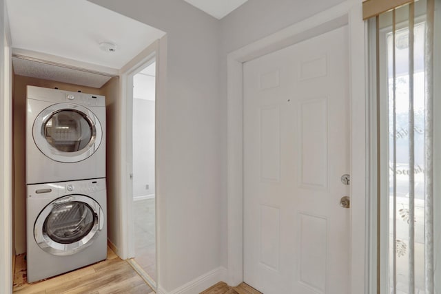 washroom featuring stacked washer / drying machine and light wood-type flooring