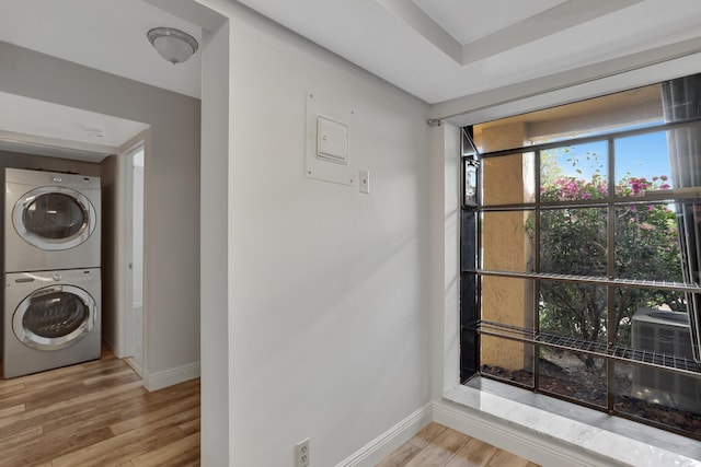 unfurnished room featuring stacked washer and dryer and light wood-type flooring