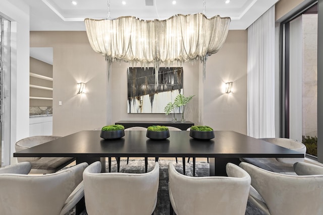 dining area with a raised ceiling and a chandelier