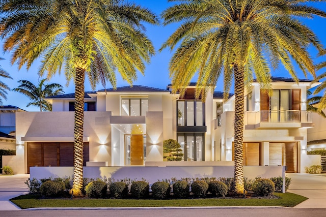 view of front of property with a garage, concrete driveway, and stucco siding