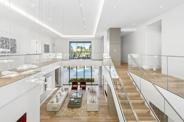 foyer entrance featuring light hardwood / wood-style floors, a high ceiling, and an inviting chandelier