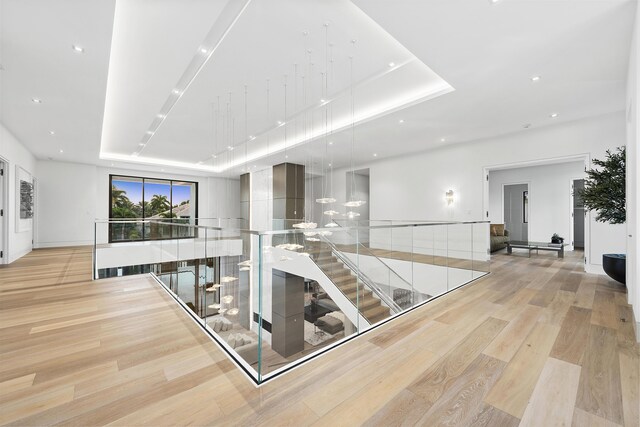 interior space featuring a raised ceiling and light hardwood / wood-style flooring