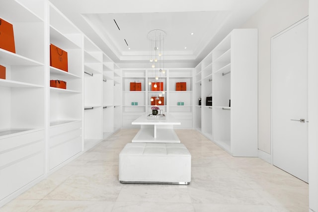 walk in closet featuring a tray ceiling