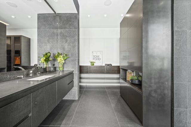 bathroom featuring vanity and tile walls