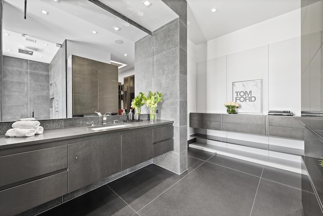 bathroom featuring vanity, walk in shower, and tile walls