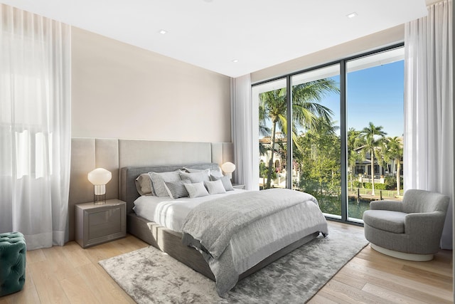 bedroom with access to exterior and light wood-type flooring