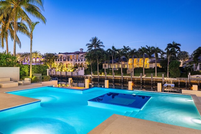 pool at dusk with a patio and an outdoor fire pit