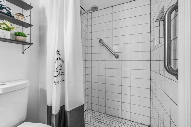 bathroom featuring a shower with shower curtain, toilet, and tile flooring