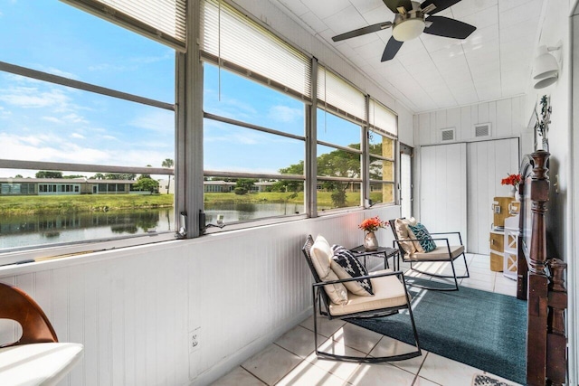 sunroom / solarium with ceiling fan and a water view