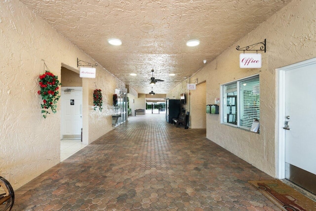 corridor featuring a textured ceiling and tile flooring