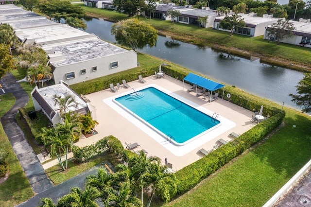 view of pool with a patio area, a yard, and a water view