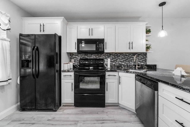 kitchen with pendant lighting, white cabinetry, black appliances, sink, and light hardwood / wood-style floors