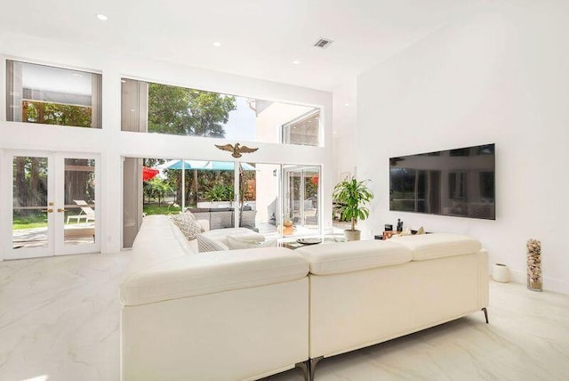 living room with a high ceiling and french doors