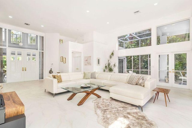 living room with french doors and a towering ceiling