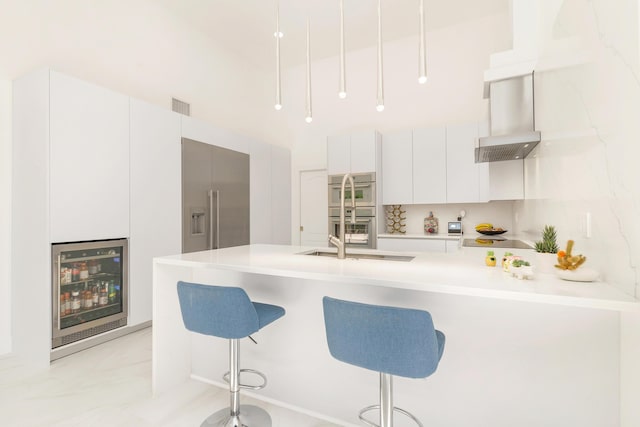 kitchen featuring white cabinets, island range hood, beverage cooler, and a kitchen breakfast bar